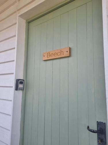 a door with a sign that says beach on it at Beech, Country Chalet In Pegsdon in Hexton