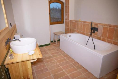 a bathroom with a bath tub and a sink at Vale das Maias - Casa de Campo in Laborins