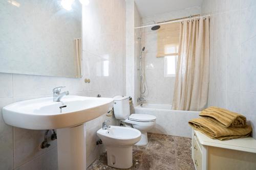 a white bathroom with a sink and a toilet at Villa Viñedo - Agradable Villa Rústica con Jardín in Sotillo de las Palomas