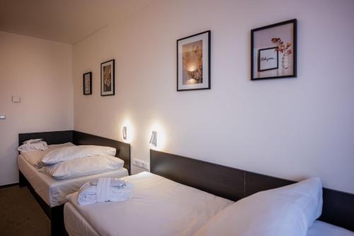 two beds in a hotel room with two beds at Wellness Hotel Frymburk in Frymburk