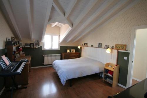 Schlafzimmer mit einem Bett, einem Schreibtisch und einer Tastatur in der Unterkunft La Casa de Gene in Ruilobuca