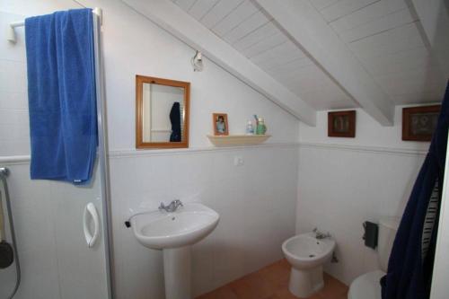 uma casa de banho branca com um lavatório e um WC em La Casa de Gene em Ruilobuca