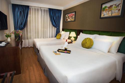 two large beds in a hotel room with blue curtains at Aviary Hanoi Hotel & Travel in Hanoi