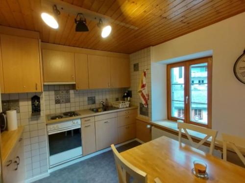 eine Küche mit einem Holztisch und einer Holzdecke in der Unterkunft Centre Ville Appartement in Leukerbad
