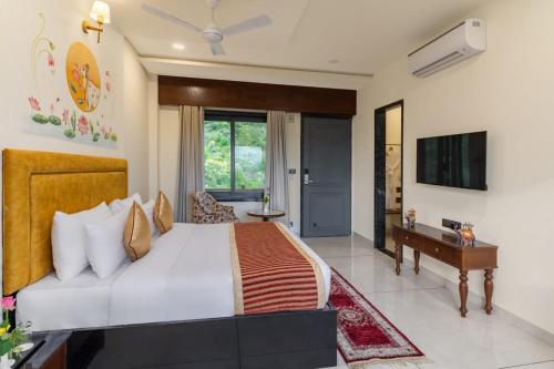 a bedroom with a large bed and a television at Traavista Aravali Mahal - Luxury Lake View Heritage Resort in Udaipur in Udaipur