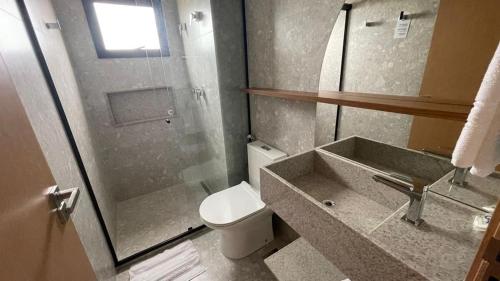 a bathroom with a toilet and a sink and a shower at Salinas Premium Resort in Salinópolis