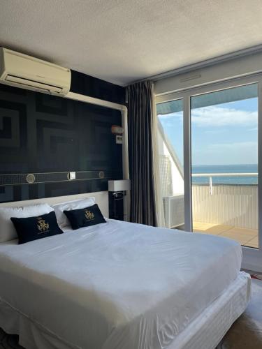 a bedroom with a large bed with a view of the ocean at Appart'hôtel Le Trianon in Arcachon