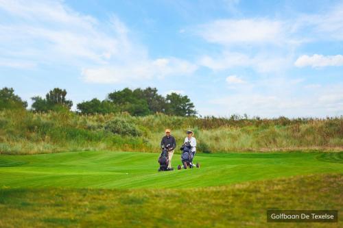 a couple of people standing on a golf course at Vakantiepark De Krim Texel in De Cocksdorp