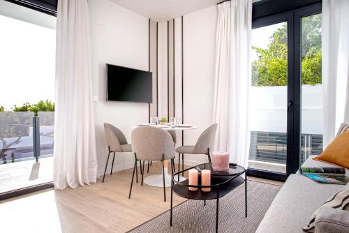 uma sala de estar com uma mesa e cadeiras e um sofá em Genteel Home Arruzafa em Córdoba