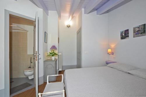 Habitación blanca con cama y aseo en Villa Borgiano, en Scansano