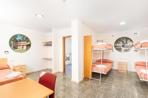 ヘレス・デ・ラ・フロンテーラにあるAlbergue Inturjoven Jerez De La Fronteraの二段ベッドとテーブルが備わる客室です。