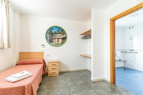 ヘレス・デ・ラ・フロンテーラにあるAlbergue Inturjoven Jerez De La Fronteraのベッド1台とバスルームが備わる小さな客室です。