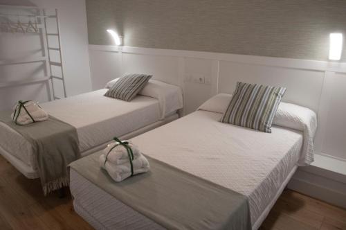 two beds in a room with white walls at Torre de Ambroz in Plasencia