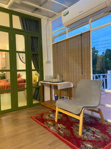 uma sala de estar com uma cadeira e uma mesa em Virawan pool kohlarn วิราวัน พลู รีสอร์ต ที่พักเกาะล้าน em Ko Larn