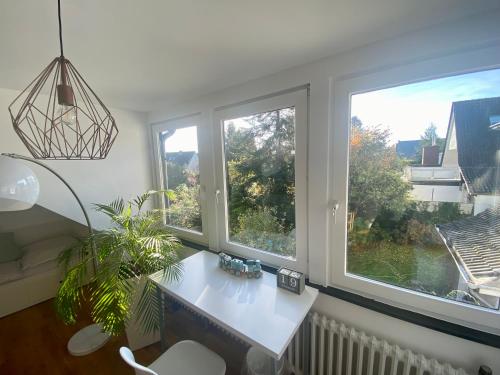 a living room with a table and two windows at (Messe)Zimmer mit Bad und Ankleideraum + Parkplatz in Düsseldorf
