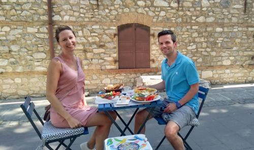 a man and a woman sitting at a table with a plate of food at Urkmez Hotel in Selcuk