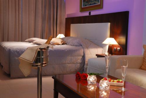 a bedroom with a bed and a living room with a table at Panorama Hotel in Paralia Katerinis
