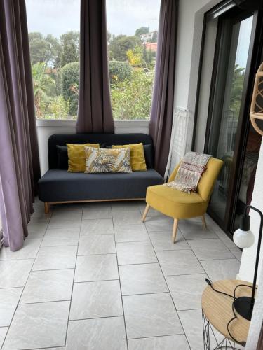 un salon avec un canapé et une fenêtre dans l'établissement Les cigales, au Lavandou