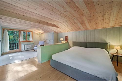 um quarto com uma cama grande e um tecto de madeira em Chesa Alvan - Surlej em Surlej