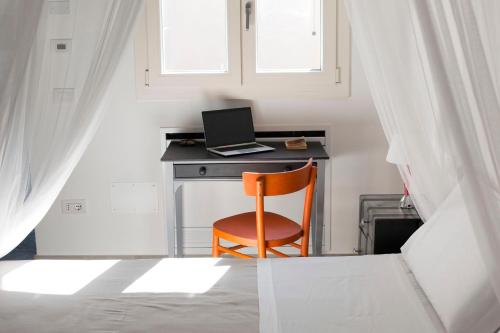 a desk with a laptop and a chair in a room at AMORE RENTALS - Villa Ambretta in Campagnatico