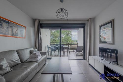 sala de estar con sofá y mesa en Le Backspin - Appartement moderne avec terrasse, en Saint-Cyprien