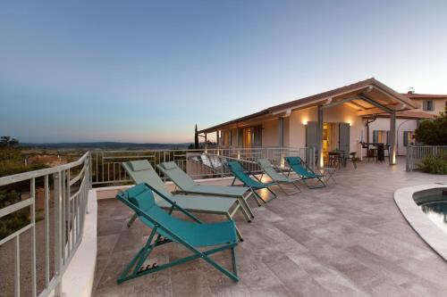 a deck with chairs and a swimming pool on a house at AMORE RENTALS - Villa Ambretta in Campagnatico