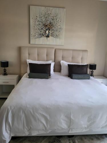 a large white bed with two pillows on it at Ultimate Sky in Pretoria
