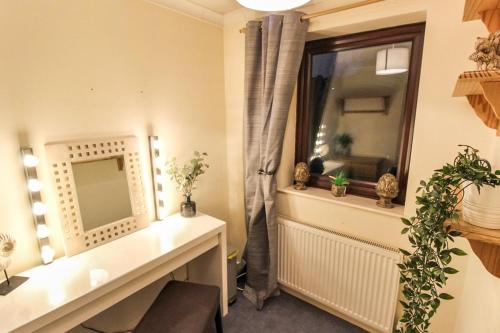 a room with a window with a desk and a mirror at Comfortable 2 Bedroom House with Free Parking in Nottingham