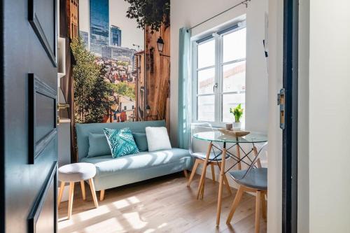 un salon avec un canapé et une table dans l'établissement L'Impérial - St Genis Centre, à Saint-Genis-Laval