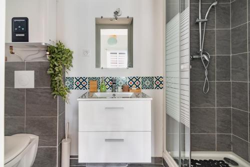 a bathroom with a white sink and a shower at L'Impérial - St Genis Centre in Saint-Genis-Laval