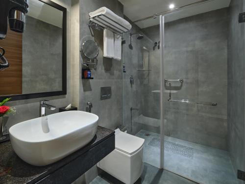 y baño con lavabo blanco y ducha. en Essentia Premier Hotel Chennai OMR en Chennai