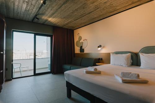 ein Hotelzimmer mit einem Bett und einem Balkon in der Unterkunft ibis Styles ST Pauls Bay Malta in St Paul's Bay