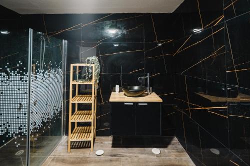 a bathroom with a black wall with gold lines at לופט נור in Mitzpe Ramon