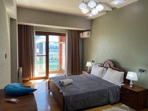 a bedroom with a large bed and a large window at Park Azure Sky apartment in Baku