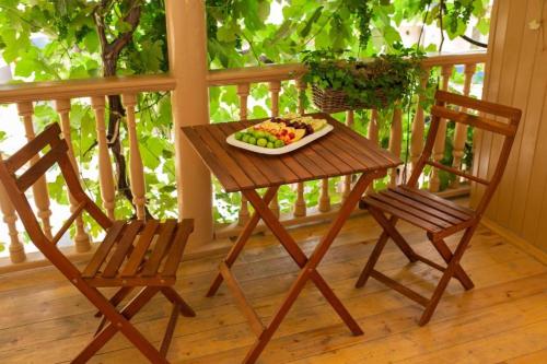 a table and two chairs on a porch with a plate of fruit at History Hotel Tbilisi in Tbilisi City