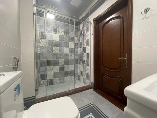 a bathroom with a shower and a toilet and a sink at Park Azure Sky apartment in Baku