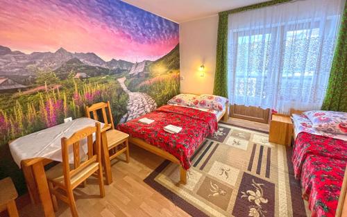 Cette petite chambre comprend 2 lits et une fresque murale. dans l'établissement Domki i pokoje Toporówka, à Zakopane