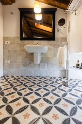 a bathroom with a sink and a tiled floor at CORTE SAGGIN Charme Relais in San Pietro in Cariano