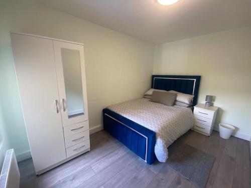 a bedroom with a bed and a dresser and a mirror at MBA COSY 4 bedroom house in Leavesden Green