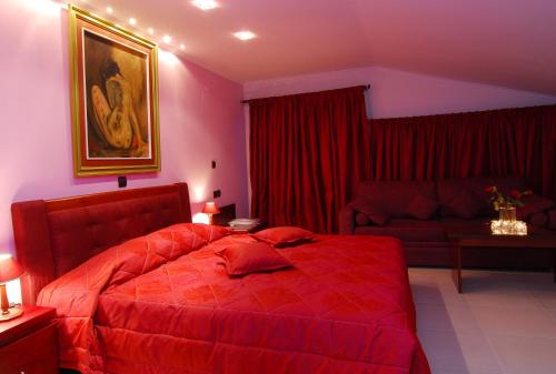 a bedroom with a red bed and a couch at Panorama Hotel in Paralia Katerinis