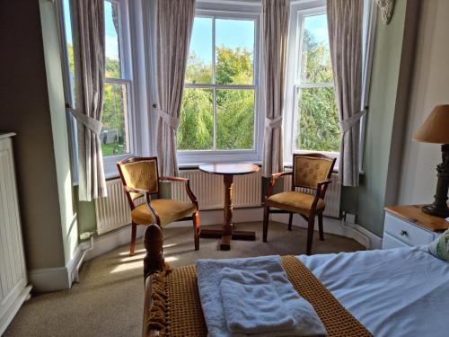 a bedroom with a bed and two chairs and a table at The Three Horseshoes East Worldham in Alton