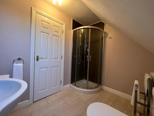 a bathroom with a shower and a sink and a toilet at Spacious Townhouse with Parking in Telford
