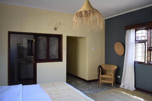 a bedroom with a bed and a chandelier at Stasumo House Arusha in Arusha