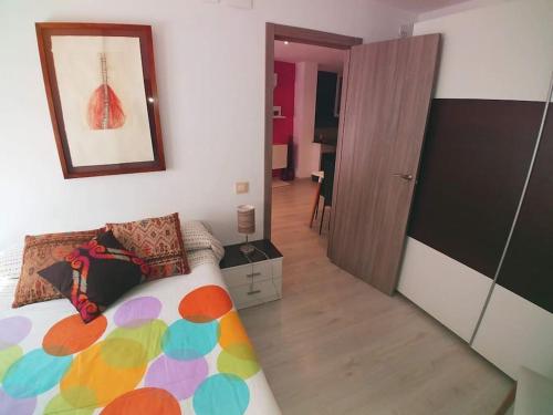 une chambre avec un lit avec une couette colorée dans l'établissement El Vinilo. Aparcamiento exterior gratuito, à Teruel