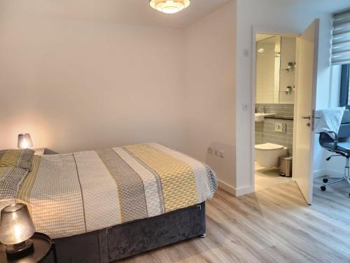 a bedroom with a bed and a bathroom at Lovely Luxury Apartment with Free Parking 801 in Luton