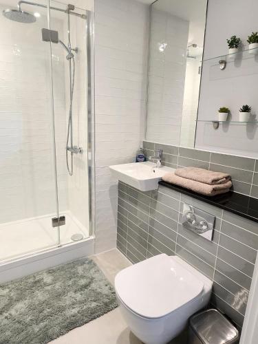 y baño con aseo, lavabo y ducha. en Lovely Luxury Apartment with Free Parking 801, en Luton