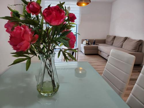 um vaso de rosas numa mesa numa sala de estar em Lovely Luxury Apartment with Free Parking 801 em Luton