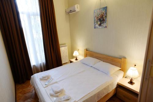 a bedroom with a bed with two towels on it at Tunti's Apartments in Tbilisi City