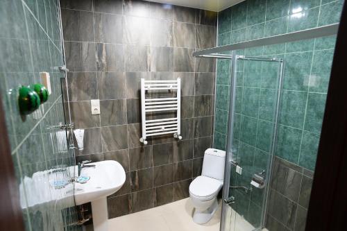 a bathroom with a toilet and a shower and a sink at Tunti's Apartments in Tbilisi City