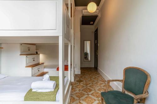 a bedroom with a bed and a green chair at Casa Gracia in Barcelona